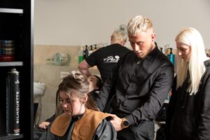 Students learning how to be hair stylists and cut hair